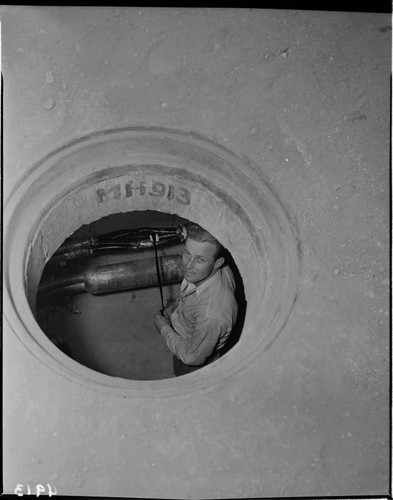 View Through Manhole Of Man Working In Underground Transformer Vault