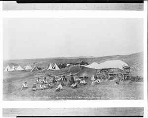 Photograph by L. A. Huffman in 1887 of "Old Powder River Days," showing the S L Boys at dinner when the cooks did their work by the open fire, Montana(?), 1887