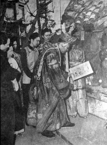 Los Angeles Times photo, p. 2- "Be discreet oh wise one--after placing sticky candy in the spirits' shrine to keep him from talking too much, Abbot Yu Feng Sung burns picture of heavenly emissary releasing him to report behavior of Chinese during the year now ending." Pagoda in the background and Dorothy Siu is fourth from the left