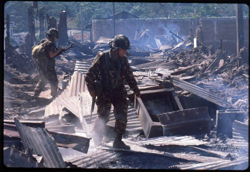 Salvadoran Army troops walk through debris after bombing, Berlín, 1983