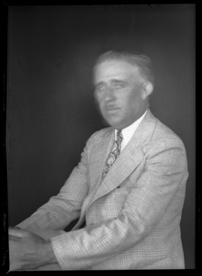 Portrait of man in suit sitting with legs crossed