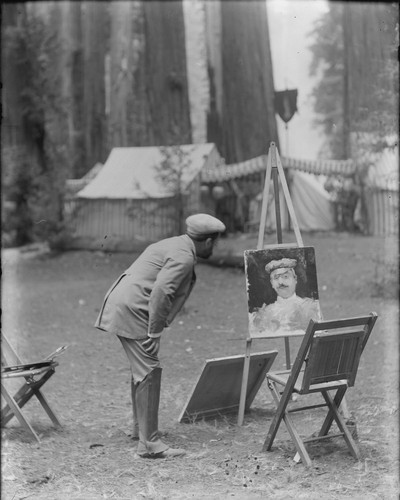 Man looking at portrait, Bohemian Grove. [negative]