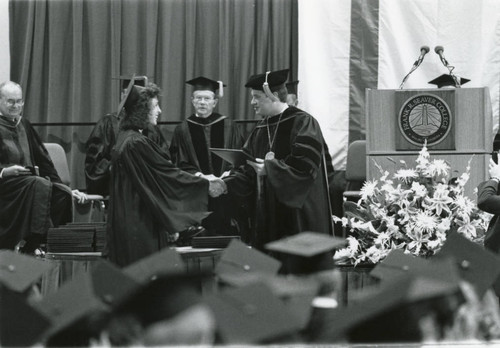 President Davenport presenting a diploma to a student