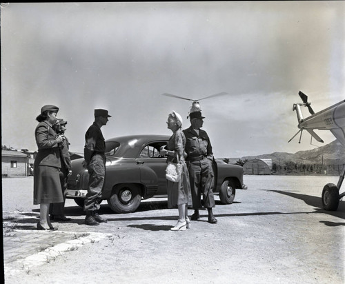 Military officers talking with Maurine Clark outside her car