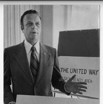 Frank B. Horner, in front of a United Way fund-raising goal sign for 1973-74 of $3,100,000. He was a manager at Sears