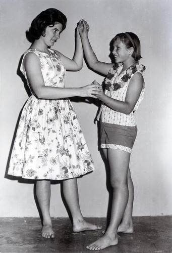 Two girls pose as if dancing