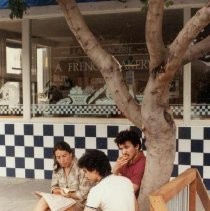 Three People Reading a Newspaper