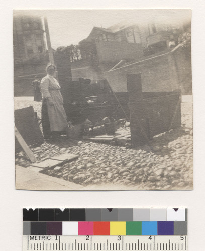 [Woman cooking in street kitchen.]
