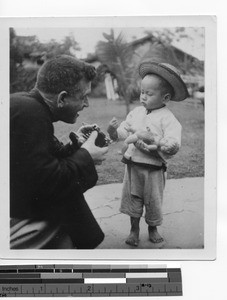 Fr. Kennelly and child in Luoding, China, 1934