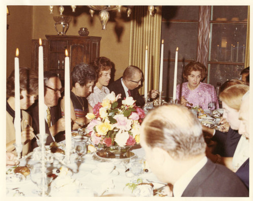 Mrs. Helen Young at the head of the table entertaining in the President's Home, LA Campus (Color)