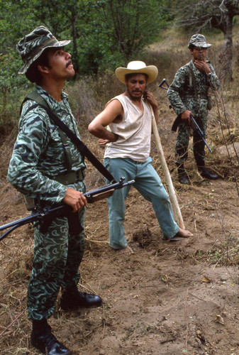 Soldiers and a barefoot farmer, Guatemala, 1982