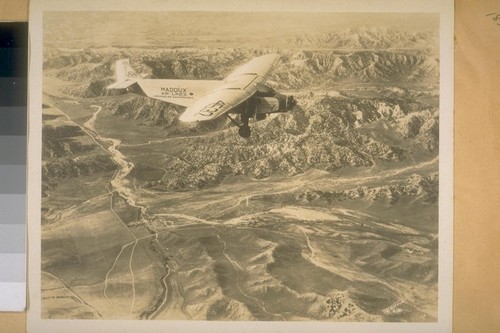 Nov. 1928. [Airplane in flight; Maddux air lines]