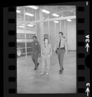 Charles Manson, escorted by two Los Angeles Sheriffs, 1973