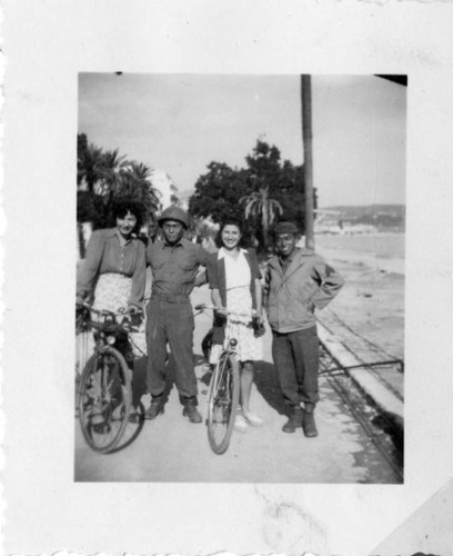 [Men in military uniform and women with bicycles]