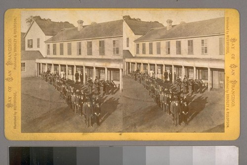 [Row of men and Band in front of Building]