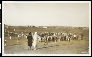 A panoramic view of a golf course while a crowd watches a golf player at Los Angeles Open tournament, ca.1930