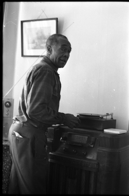 Jesse Fuller playing a vinyl record in his living room