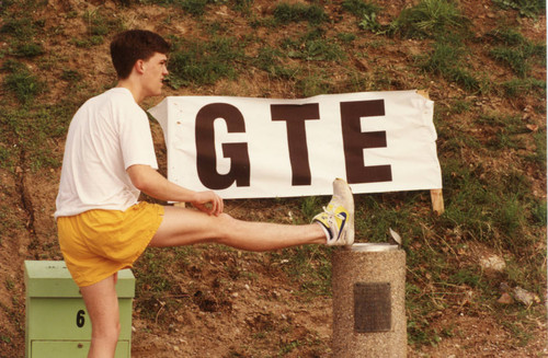 A man stretching next to the "GTE" banner