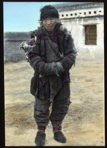 Mendicant wearing tattered clothing, China, ca.1917-1923