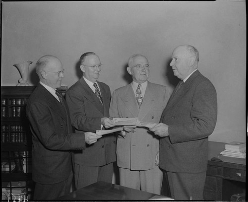 One man receiving checks from three others