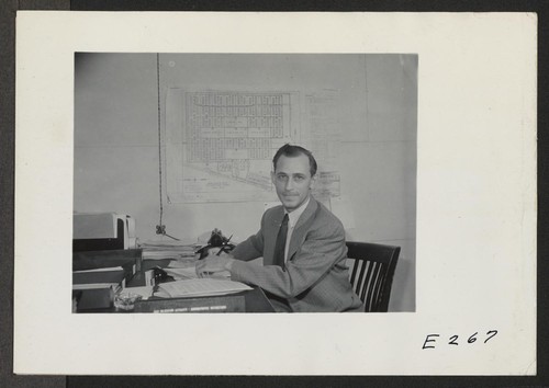 Paul A. Taylor, Project Director of this Relocation Center, seated at his desk. Photographer: Parker, Tom Denson, Arkansas