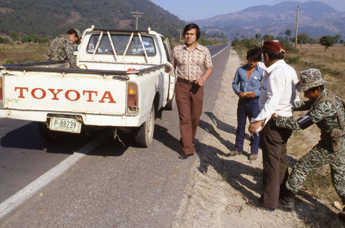 Two soldiers inspect a pickup truck and its three occupants, Chichicastenango, 1982