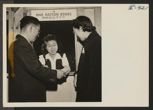 Fumi Taketa of the Heart Mountain Relocation Office is issuing War Ration Books to Mr. and Mrs. Thomas T. Sashihara