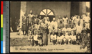 Missionary fathers standing among newly-baptized people, Congo, ca.1920-1940