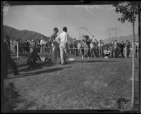 Walter Hagen waits and watches another golfer tee-off