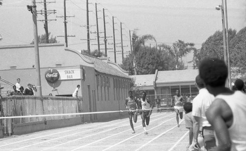 Runners at a track meet approaching the finish line, Los Angeles