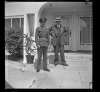 P.F.C. H. H. West, Jr. and H. H. West stand on the front steps of H. H. West's new residence, Los Angeles, 1944