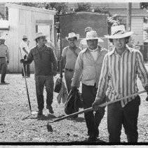 Farm workers return from the fields back to a farm labor camp