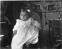 Infant in baby gown, interior photograph, c. 1912