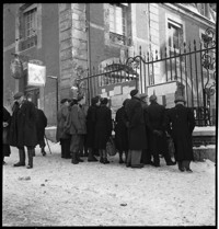 Lisieux. Mairie. [City hall: people gathered at outdoor bulletin boards, in snow]