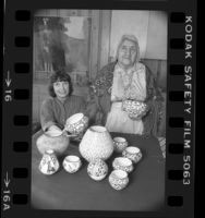 Writer and potter Susan Peterson with American Indian potter Lucy Lewis displaying Lewis' work in Los Angeles, Calif., 1984