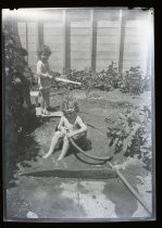 Children playing in yard with water hose