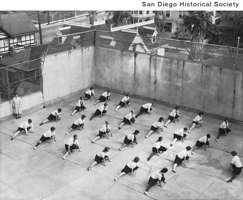 A group of female students stretching in the outdoor gymnasium at San Diego State College