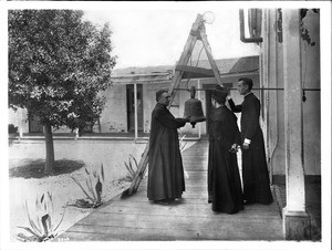 Plaza Church priest Reverend Joachim Adam and two other priests with historic bell, Los Angeles, ca.1890