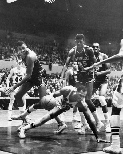 Laker Elgin Baylor tries to drive under the big Warriors Sunday night