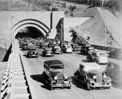 [Procession of vehicles driving through Yerba Buena Island tunnel on opening day of San Francisco-Oakland Bay Bridge]