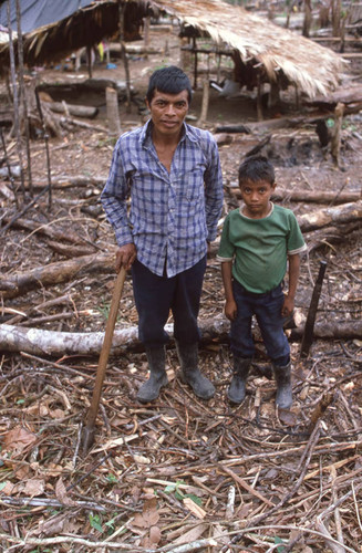 Mayan man and a child refugee stand outside, Chajul, ca. 1983