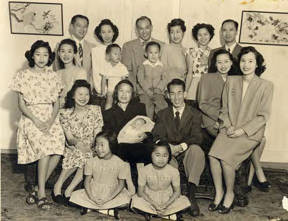 Family photo in the living room in celebration of the birth of Michael, the first Quon grandchild. Grandmother Mrs. Quan Ying sits in the center holding Michael with the parents Peggy and Milton to either side of her