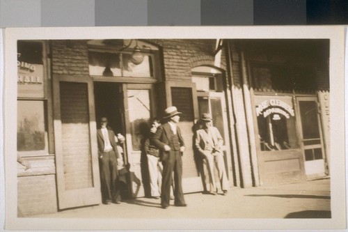 Snapshots of men in front of unidentified building