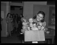 Lafayette Junior High School girl holds box of broken dolls, Los Angeles, 1938