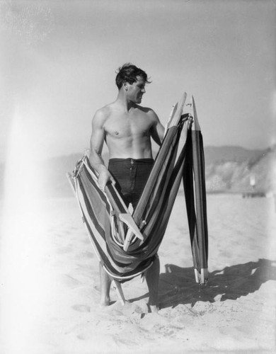 Young man holding a beach chair