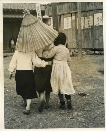 Three girls walking with parasol