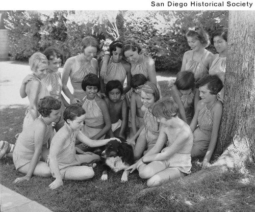 A group of girls gathered around a dog at the Resthaven Preventorium