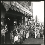 Crowd of young boys surround banjo player Eddie Peabody in front of Fox Oakland Theatre in Oakland, California