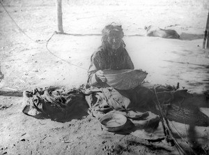 Yokut Indian woman sifting corn meal in a reed basket, Tule River Reservation near Porterville, California, ca.1900