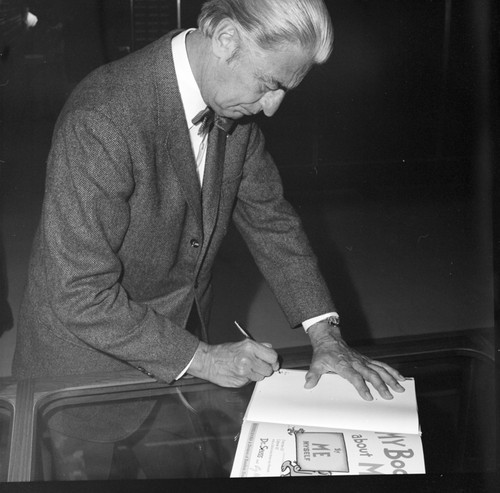 Theodor Seuss Geisel autographing books